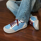 SNK AeroStitch Trainer Sky Blue on feet, seated on a wooden floor