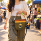 Field Green sling carried by hand at a weekend market