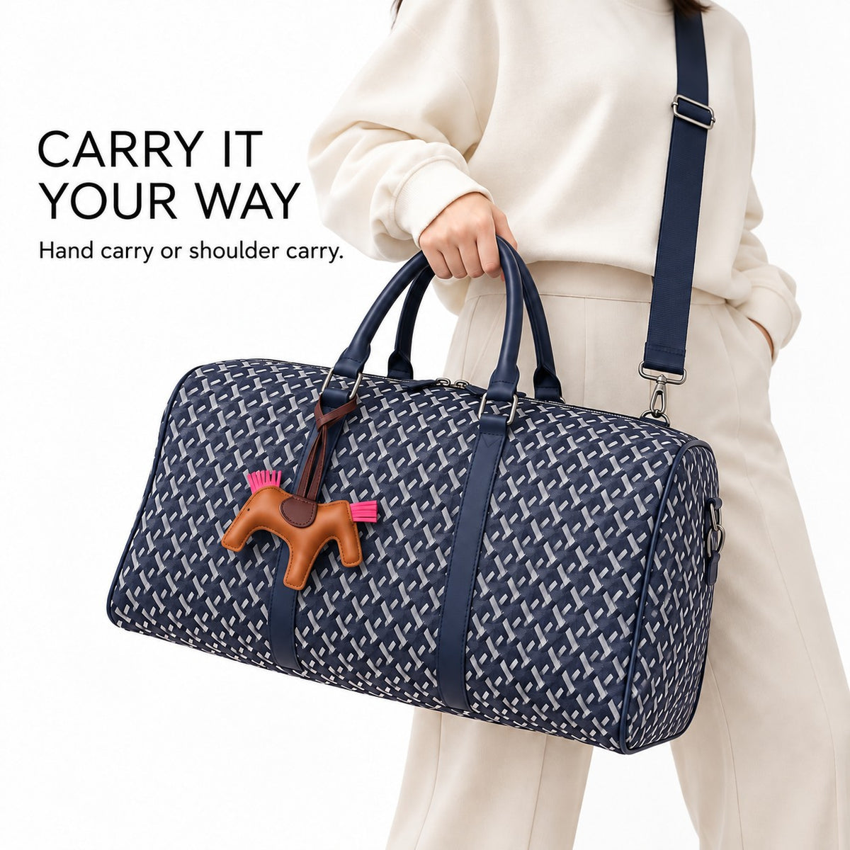 Model carrying the navy truffle bag by hand with shoulder strap attached